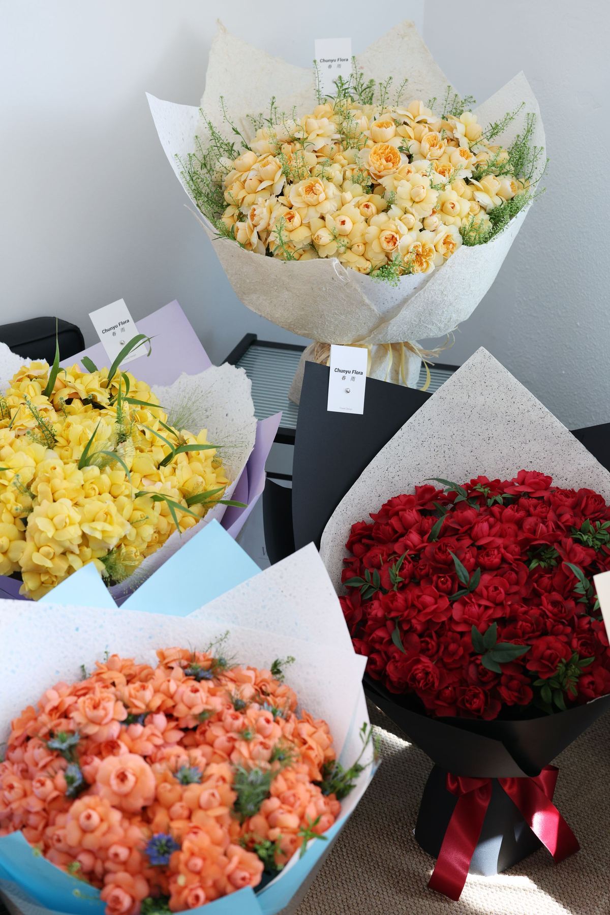 Sunlit flower shop interior with buckets of seasonal bouquets on wooden tables