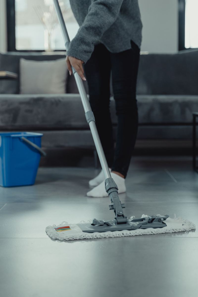 A mop gliding across clean tile floor in a bright living room